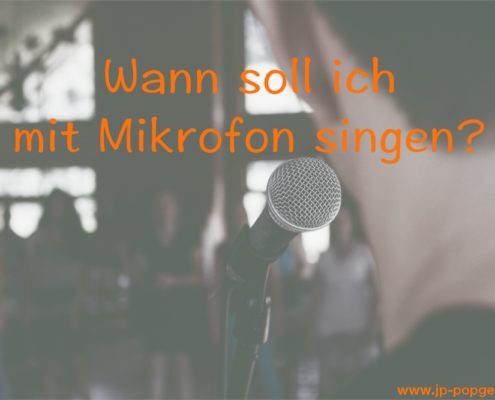 mit Mikrofon singen Das Foto zeigt einen Mann vor einem Mikrofon.
