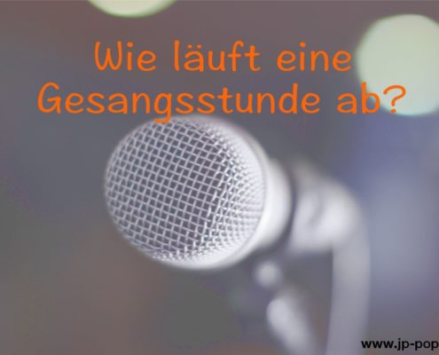 Wie läuft Gesangsunterricht ab Das Foto zeigt ein Mikrofon vor einem unscharfen Hintergrund