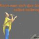 Kann man sich das Singen selbst beibringen Das Foto zeigt eine Sängerin in gelber Bluse und blauer Hose, die mit einem Mikrofon auf einer Bühne singt.