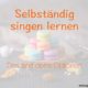 Selbständig singen lernen Das Foto zeigt bunte Macarons, die auf einem Holzteller zu einer Pyramide gestapelt wurden.