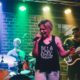 Gefühlvoll singen Auf einer Bühne singt eine Sängerin mit starker Emotion.