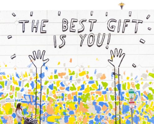 Das beste Geschenk bist du! steht in einem bunten Graffiti auf einer Wand.
